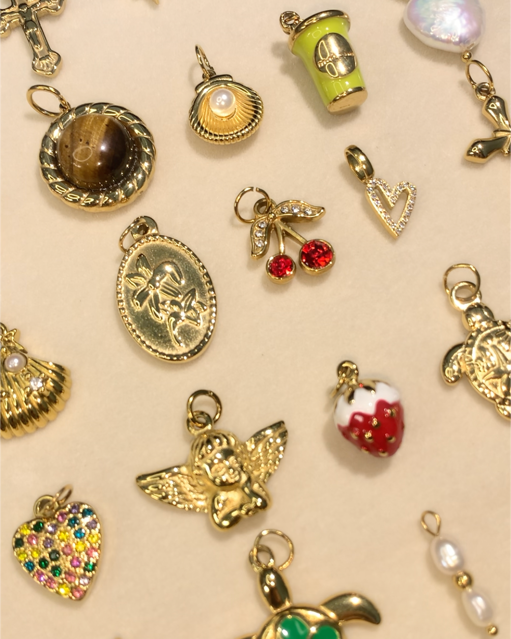 Collection of various small jewelry charms on a beige background